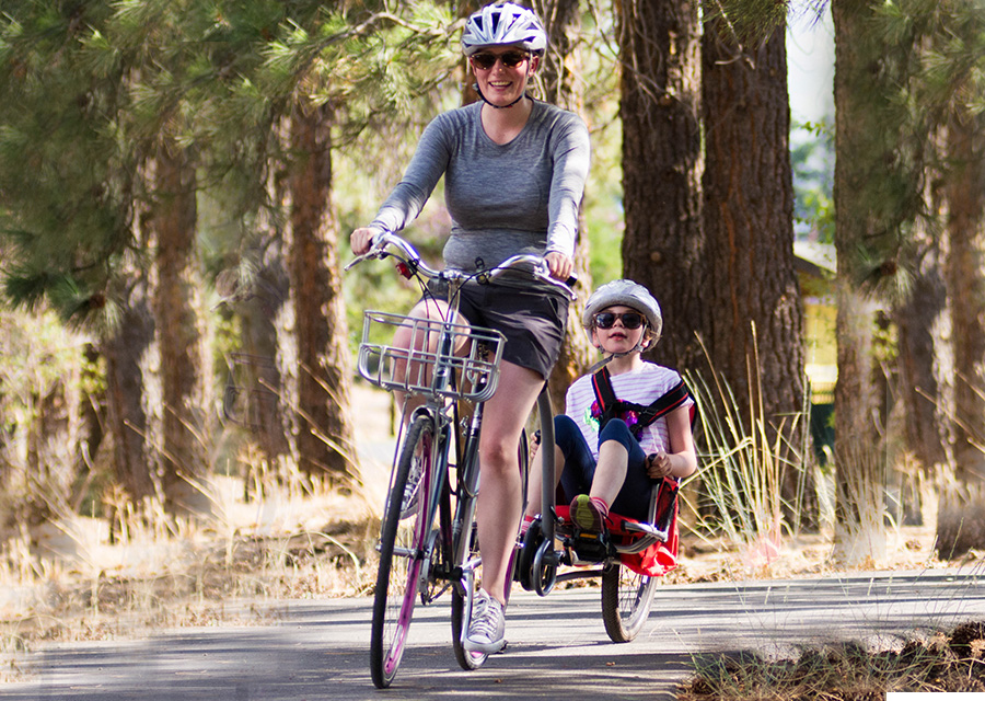 cyclist towing a youth in a bike trailer