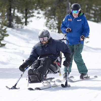 Man with disability and Winter Sports, handicapped persons and Mono Ski,  handicapped racer goes downhill on mono ski Stock Photo