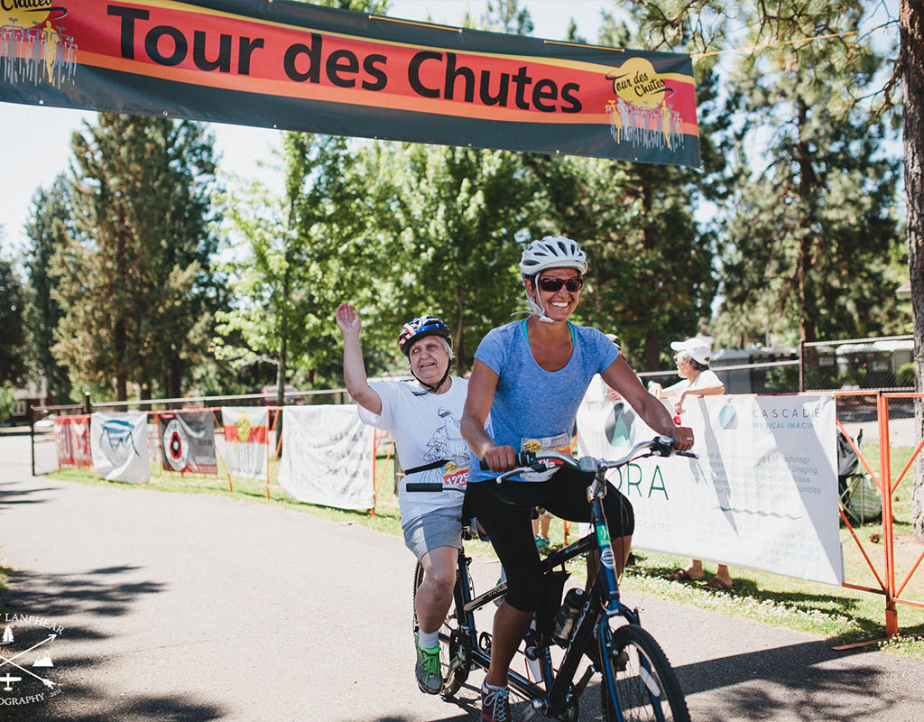 cyclist on tandem cycle at finish line of tour des chutes