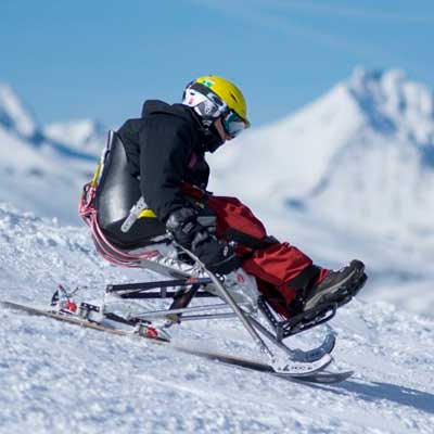 Man with disability and Winter Sports, handicapped persons and Mono Ski,  handicapped racer goes downhill on mono ski Stock Photo