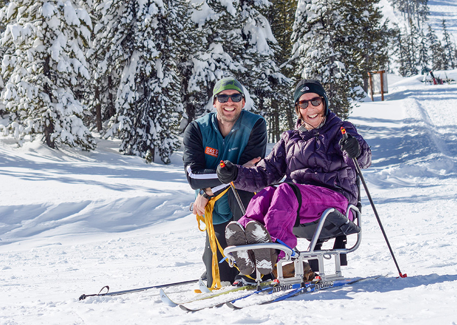 athlete in a sit cross country ski with a guide