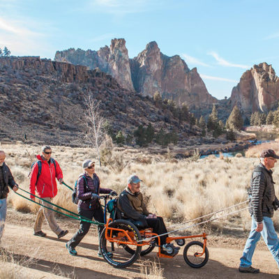 group of people including one using a specialized wheelchair hiking at Smith Rock State Park