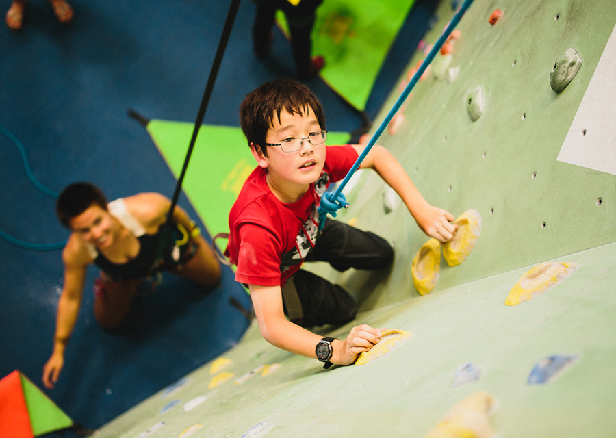 youth rock climbing in a climbing gym