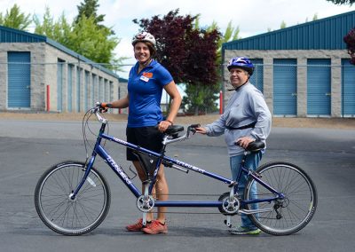 oas staff and participant with tandem bike in OAs office parking lot