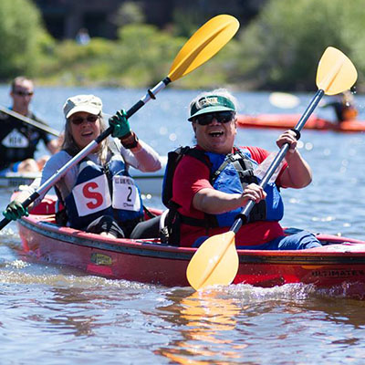 kayakers paddling in tandem boat in the pole pedal paddle race