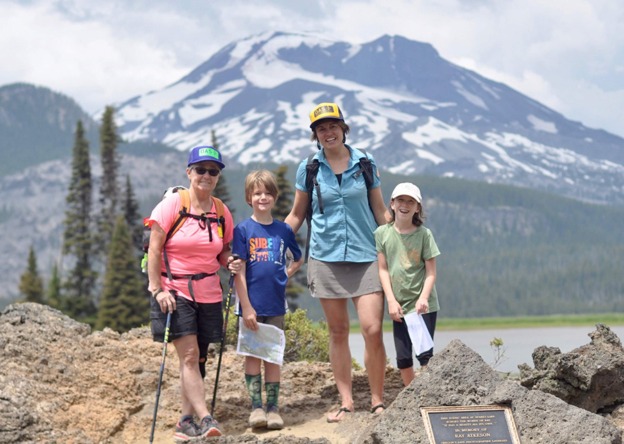 youth and adults posing for a photo while hiking near Sparks Lake