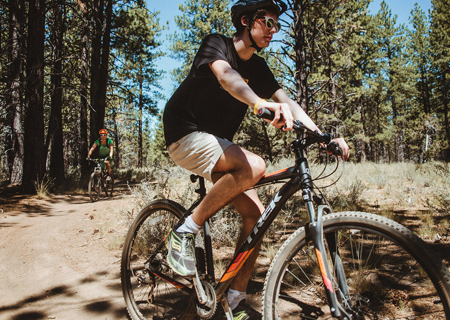 youth mountain biking on a trail