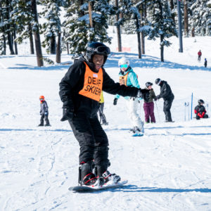 oas athlete in deaf skier bib snowboarding down hill