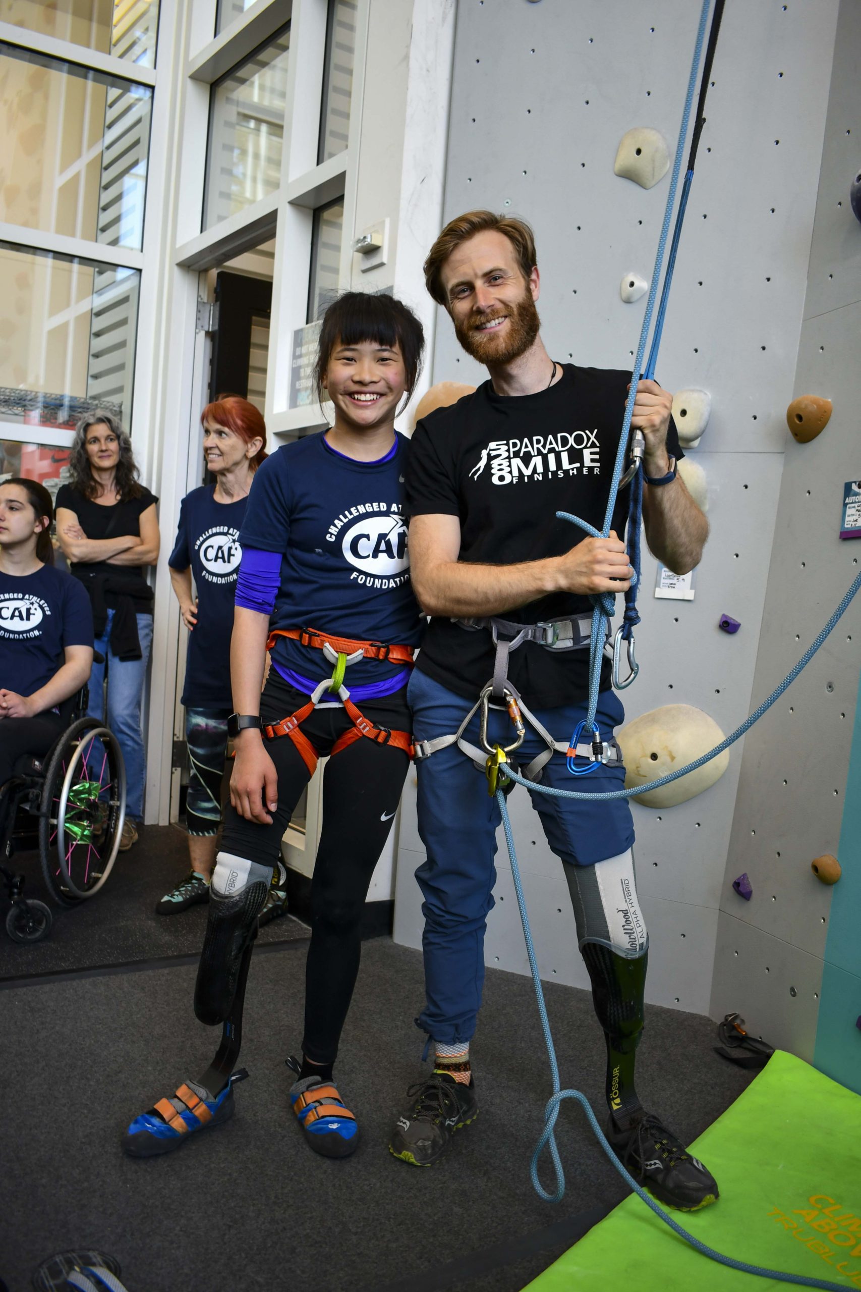 two adaptive climbers with prosthetic legs ready to climb at nike climbing facility