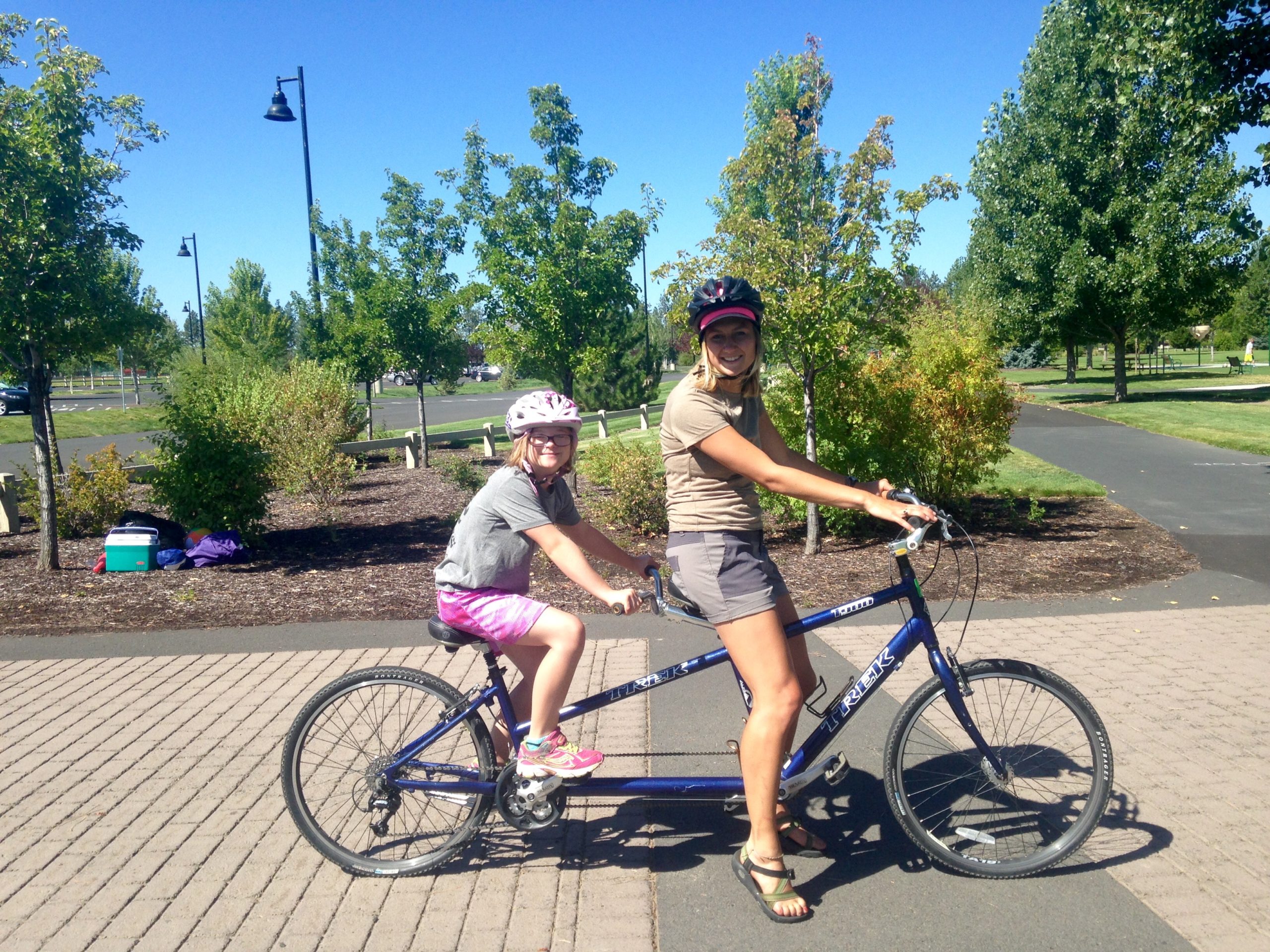 kellie and a younger smiling friend on tandem cycle