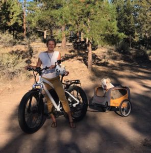 kellie on electric fat bike with dog in dog trailer