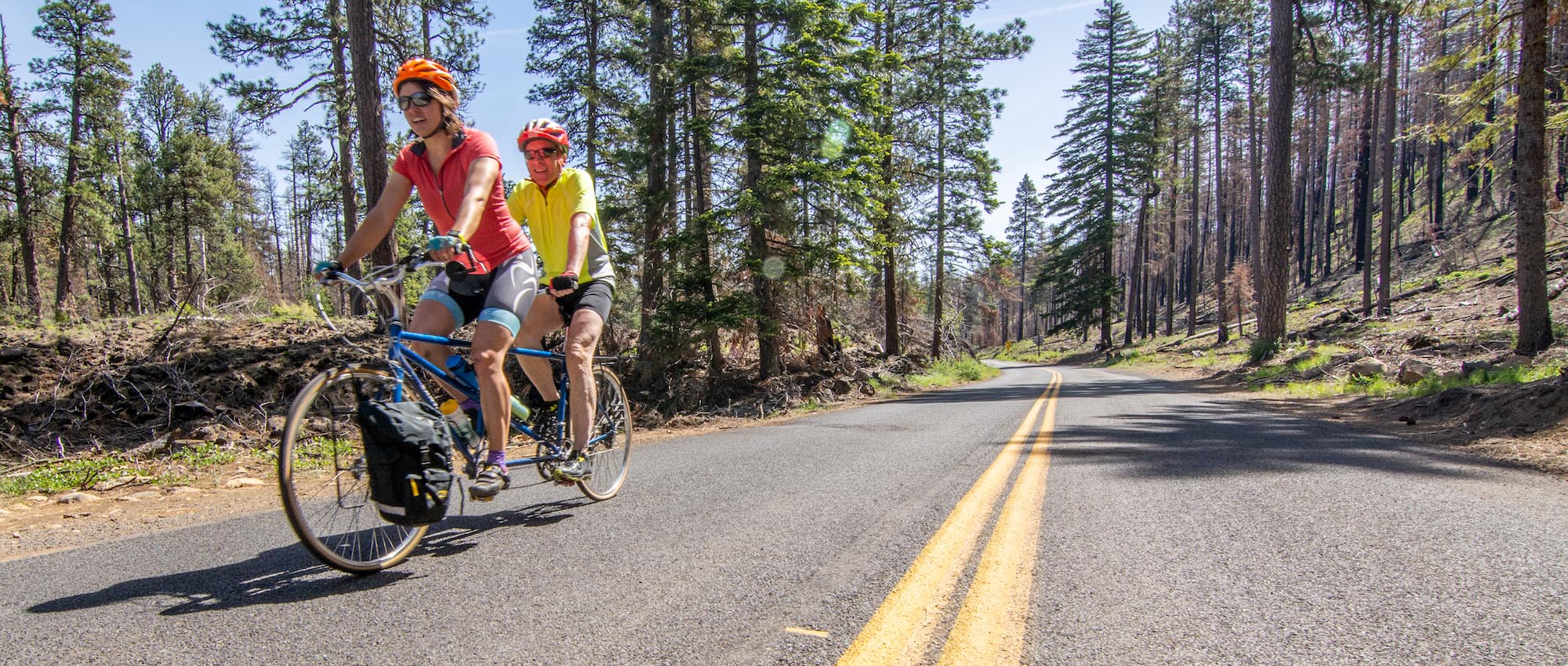 two cyclists on a tandem mountain bike on a scenic road