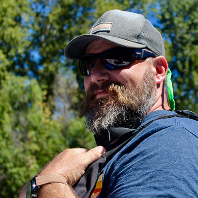 Jared wearing a hat, sunglasses and life jacket. 