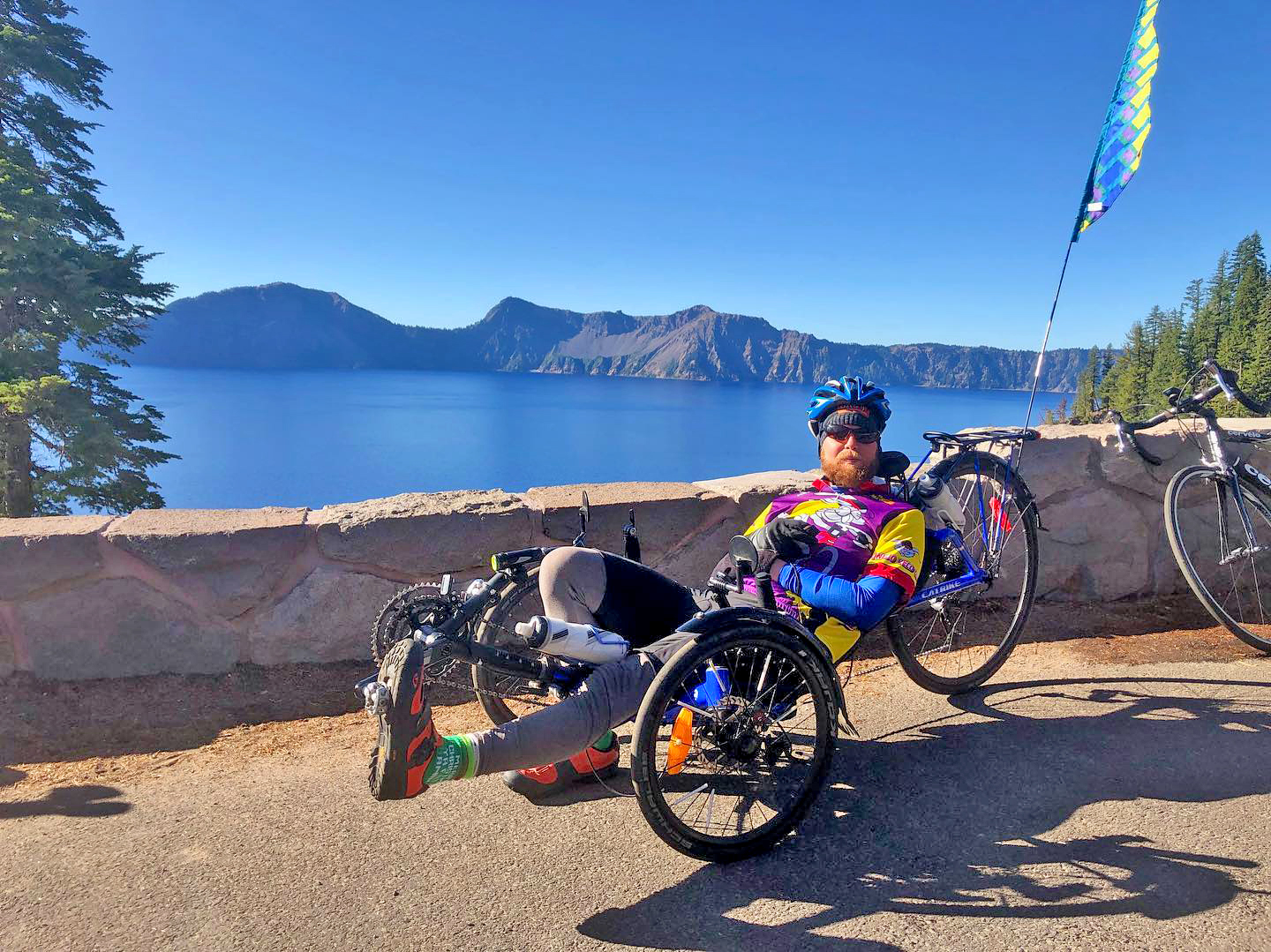 michael on a recumbent bike with crater lake in the background