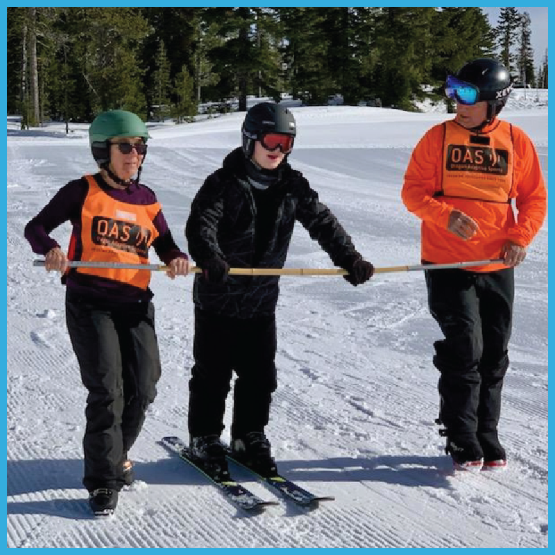 Two OAS guides utilizing a pole to guide a skier down the route during a lesson.
