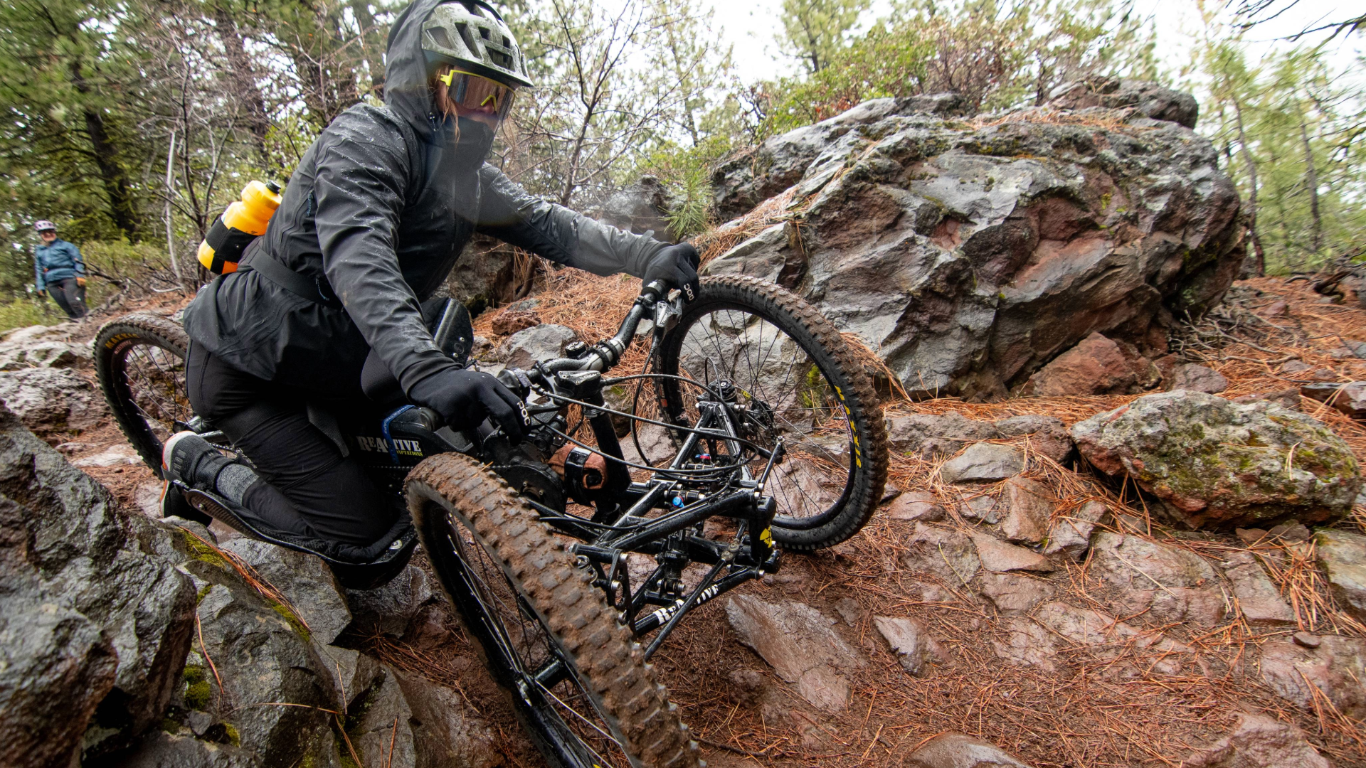 an athlete in aMTB handcycle navigates the large boulders on the trail.