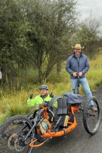 An OAS athlete gives the thumbs up from the ground beside his handcycle as the repairs continue from the a-tack.