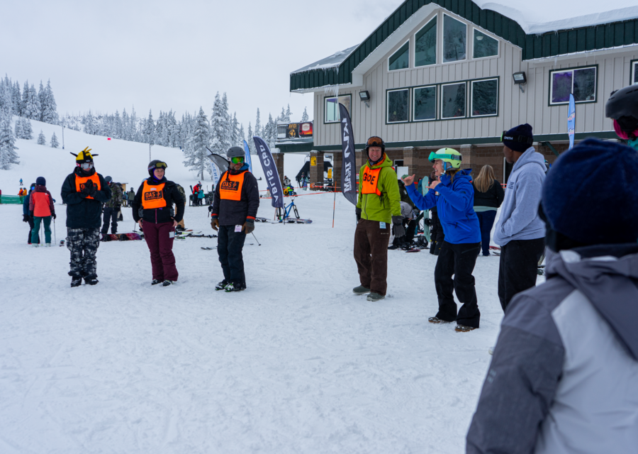 A group starts in a circle at the base of Hoodoo Ski Area outside of the lodge