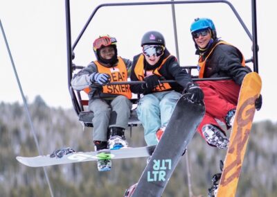 Three snowboarders on a chairlift