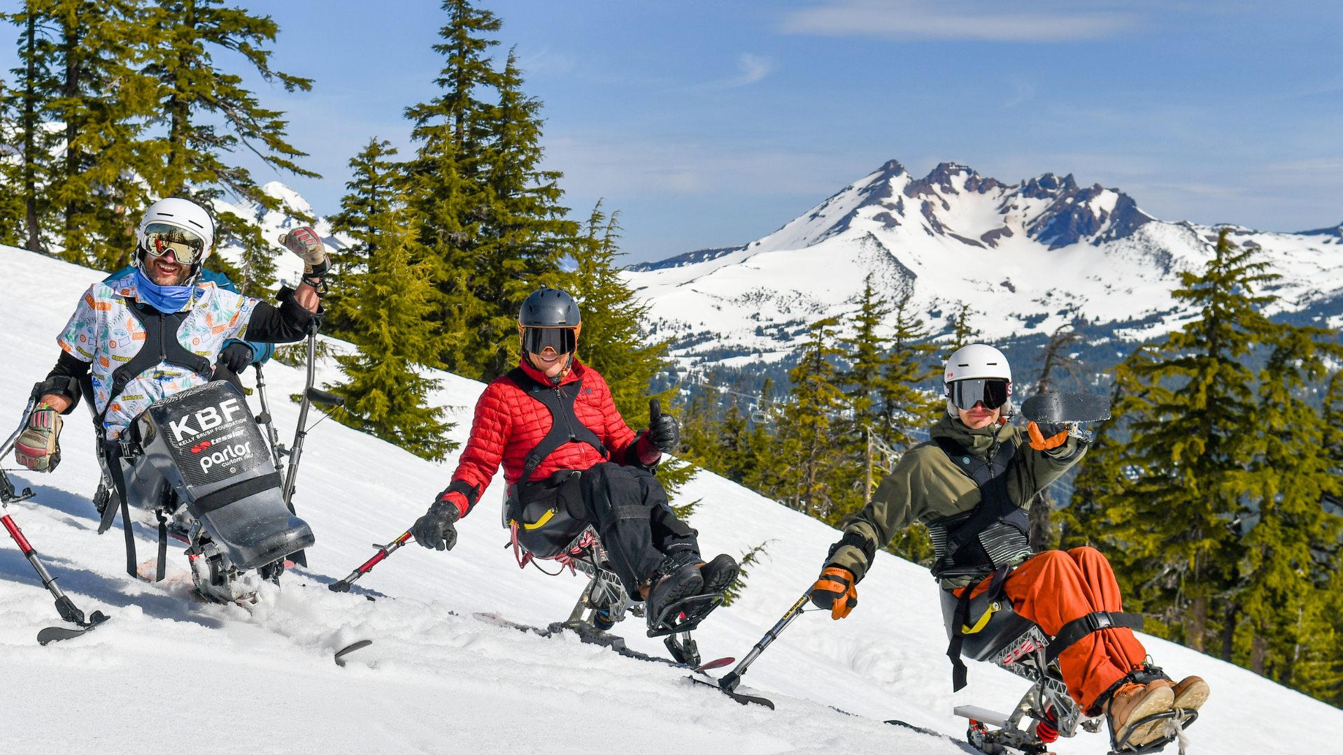 three mono skiers sit on the snowy hillside on a sunny day. Text reads "BEST DAY EVER!"