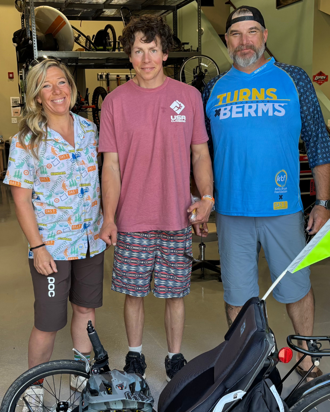 Left to right - Melodie Buell, a woman with blonde hair wearing a white button down and black bike shorts. Middle - Dave Nichols, a man with curly brown hair and a red shirt. Right - Jared Apjoke, a man with a silver and brown beard, wearing a blue runs and berms shirt.