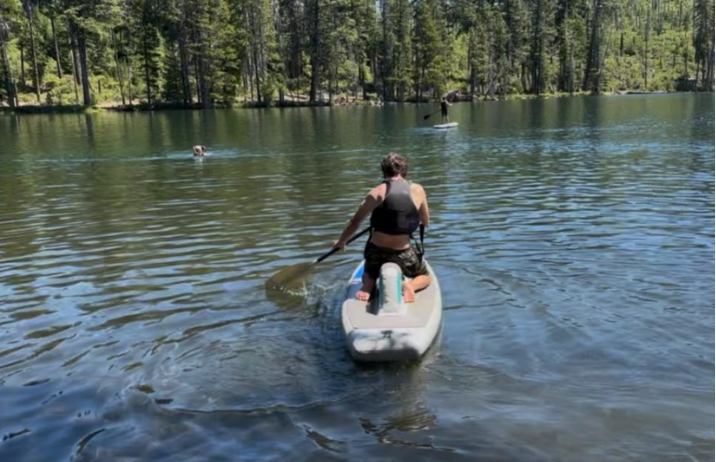Dave paddles away from shore, using the straddleboard. A board designed like a S-U-P but with foam between the knees. 