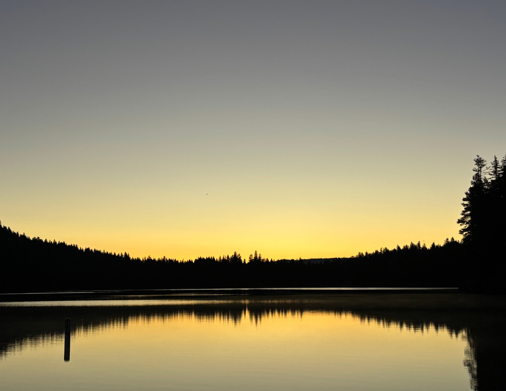 a yellow and blue-grey sunset over a glassy Suttle Lake