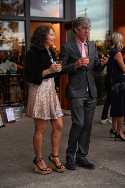 a couple in sequins watches over their bids on their phone.
