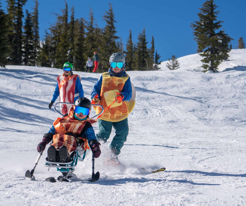 a young person in a bacon costume skis a biski while being tethered by a person in a waffle costume.