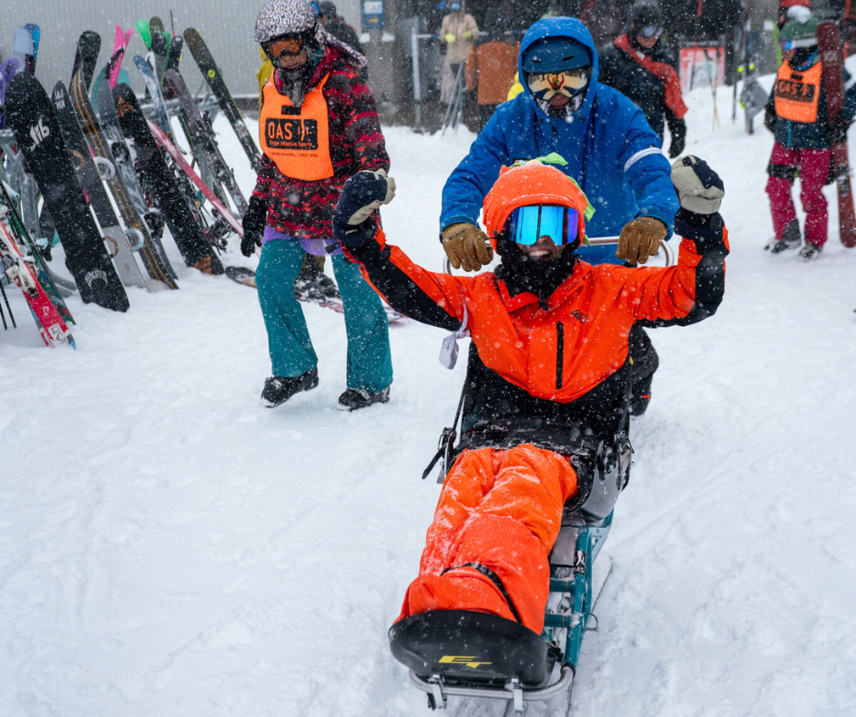 a person wearing all red raises their arms in the sky in excitement while sitting in a biski.