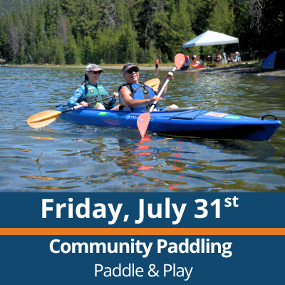 Friday, July 31st. Community Paddling. Paddle and Play. Two people paddle a blue tandem kayak across a lake, each holding a double-bladed paddle, with a forested shoreline