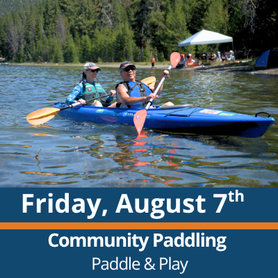 Friday, August 7th. Community Paddling. Paddle and Play. Two people paddle a blue tandem kayak across a lake, each holding a double-bladed paddle, with a forested shoreline