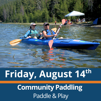 Friday, August 14th. Community Paddling. Paddle and Play. Two people paddle a blue tandem kayak across a lake, each holding a double-bladed paddle, with a forested shoreline