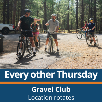 Every other Thursday. Gravel Club. Location rotates. A small group of people stand and ride bikes on a gravel area in a forest