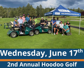 Golf course scene; a group of people pose together on and around golf carts under a blue canopy tent on green grass, with trees and cloudy skies in the background; visible text reads “Wednesday, June 17th” and “2nd Annual Hoodoo Golf Invitational.”