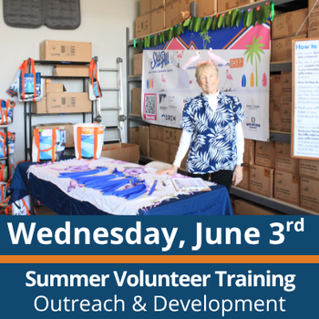 Wednesday, June 3rd. Summer Volunteer Training. Outreach and Development. A person stands behind a table indoors, smiling, with materials laid out on the table and shelves of labeled boxes stacked behind them, along with a colorful display board and signage.