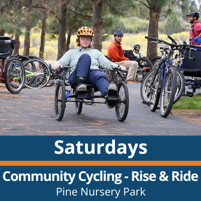 Saturdays. Community Cycling Rise and Ride. Pine Nursery Park. A person wearing a helmet rides an adaptive cycle on a paved path, with several bikes and people gathered nearby under trees in the background.