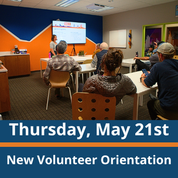 Classroom scene; a group of adults sit at tables facing a presenter standing near a screen at the front of the room; the presenter gestures toward the screen while speaking; text at the bottom reads “Thursday, May 21st” and “New Volunteer Orientation.”